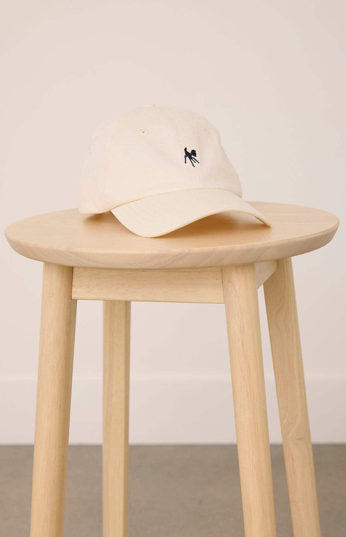 a wooden stool with a cream colored hat with a fawn logo on it