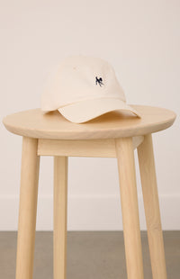 a wooden stool with a cream colored hat with a fawn logo on it