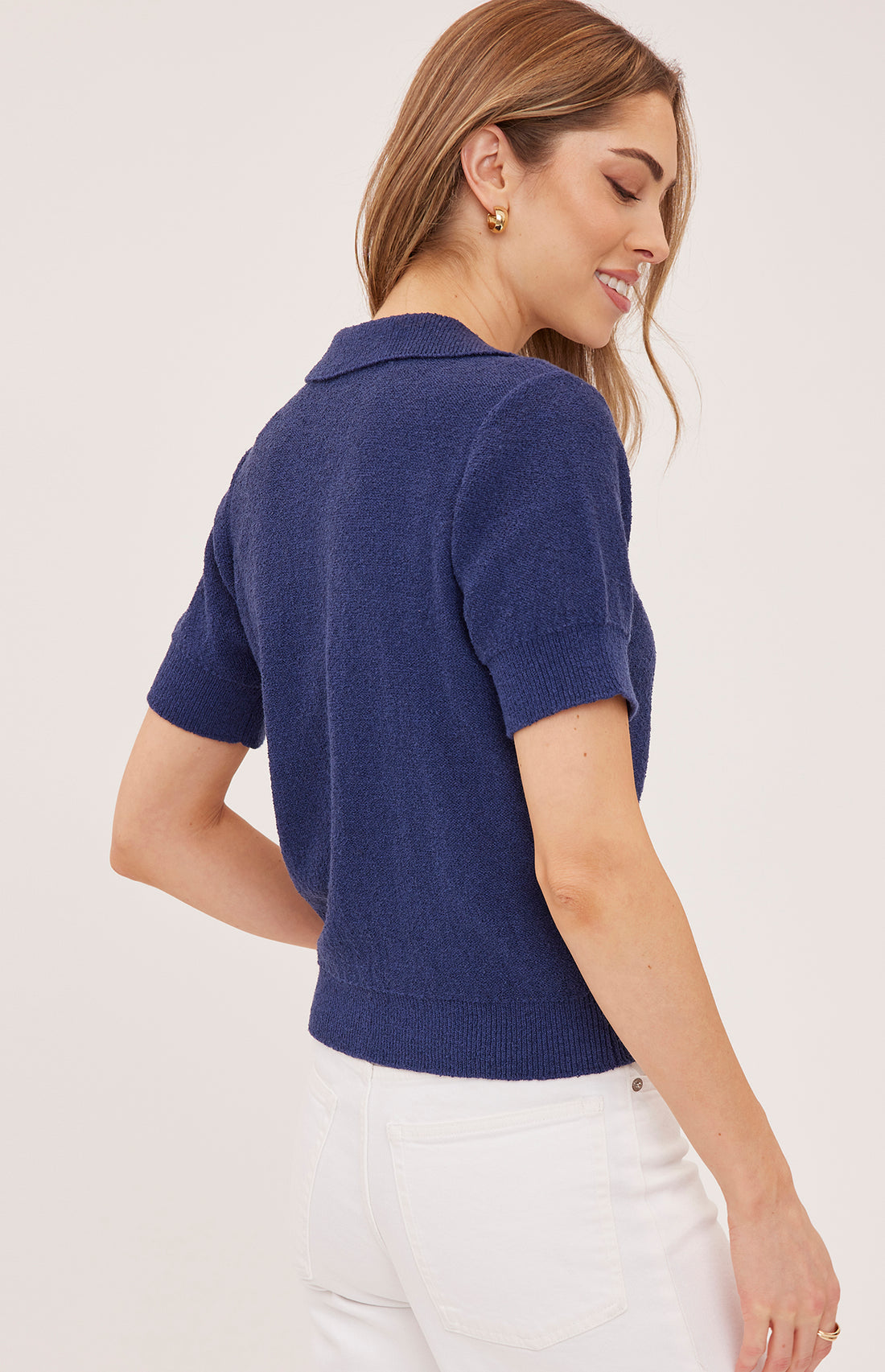 Woman wearing a blue polo shirt against a white background